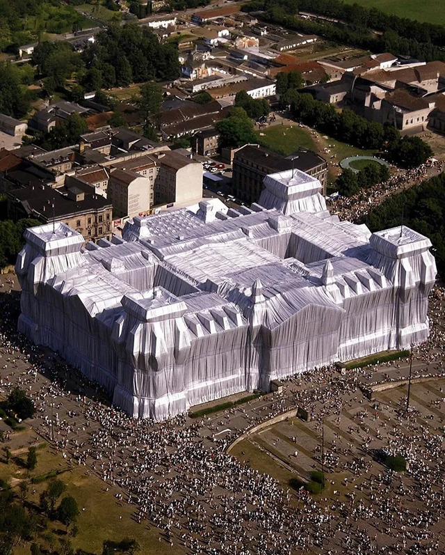 An aerial view of the Wrapped Reichstag, providing a stunning overview of the massive temporary art installation surrounded by captivated crowds.