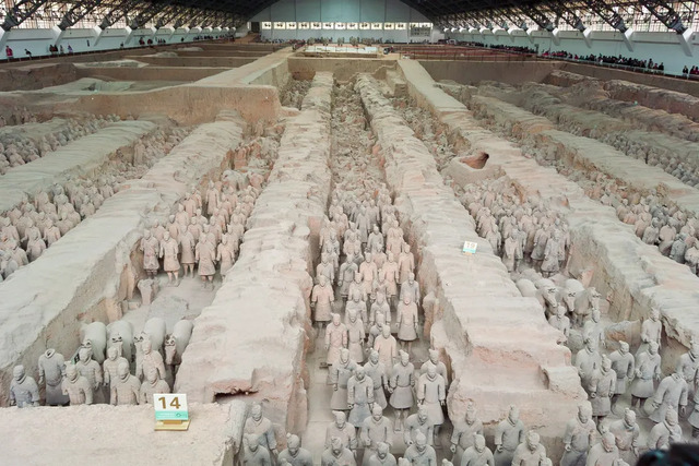 An awe-inspiring aerial view of a pit brimming with rows of terra-cotta warriors, frozen in time.