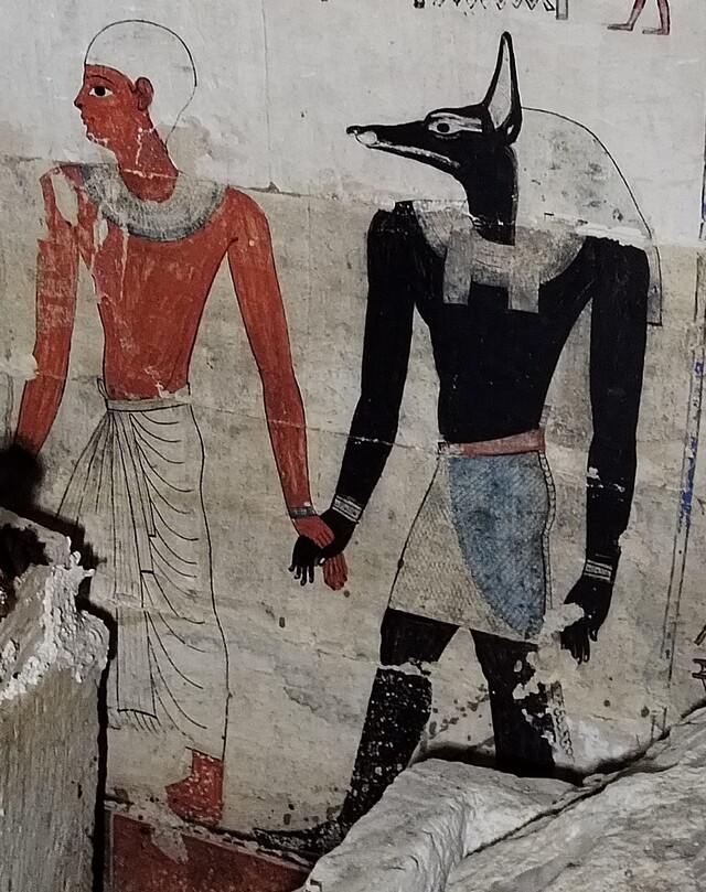 Anubis, the god of embalming, leading the deceased by hand, a classic illustration of the transition to the afterlife in ancient Egyptian art.