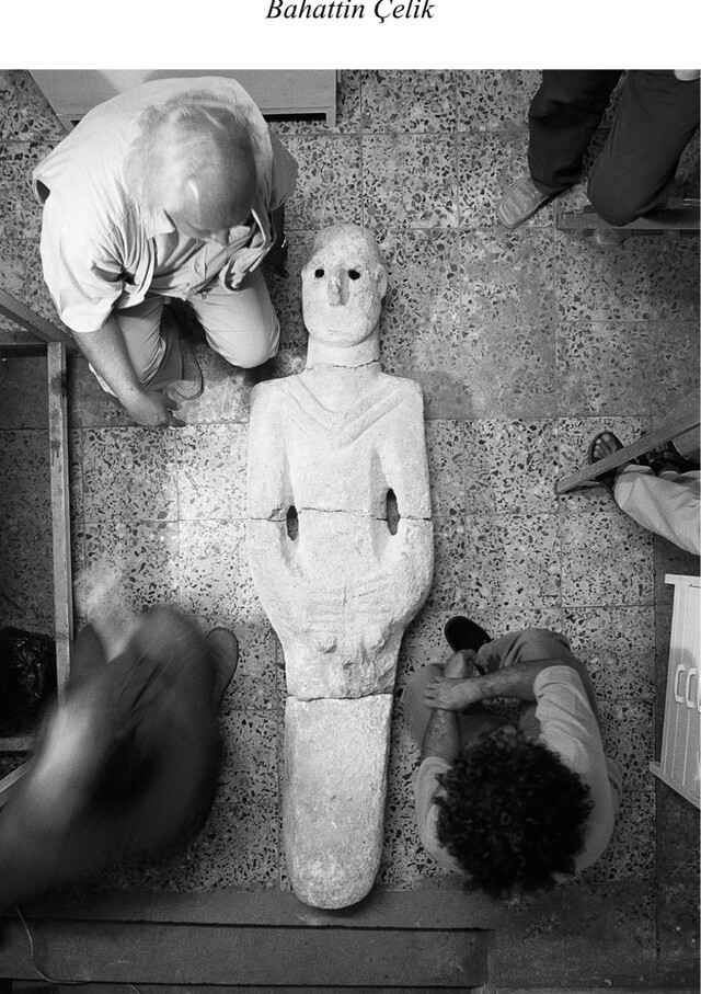 Archaeologist Bahattin Çelik examining the Urfa Man statue at the excavation site in 1993. The sculpture was found in four pieces during construction work.