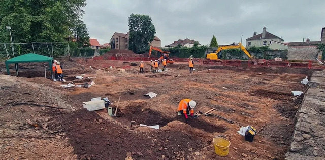 Archaeologists diligently uncover historic graves at the Blackberry Hill excavation site, revealing layers of forgotten history.