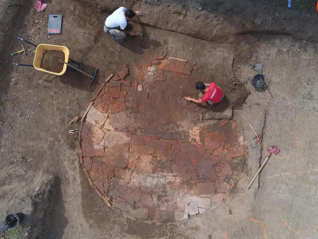 Archaeologists uncover an ancient tile wash basin, revealing its intricate design.