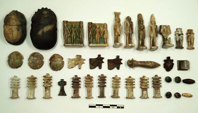 Collection of funerary amulets, including scarabs, Djed pillars, and Wadjet eyes, found within the sealed tombs, symbolizing protection and guidance in the afterlife.