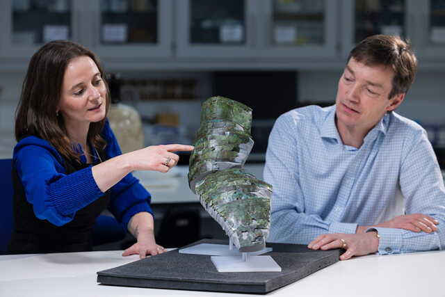 Conservator Bethan Bryan collaborates with curator Fraser Hunter to unveil the reconstructed Roman arm-guard, a piece of history reborn.