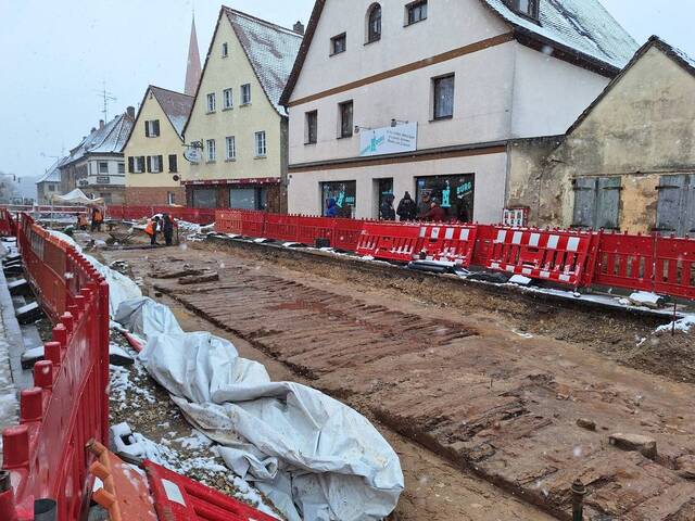 Historical artwork depicts the grand parade featuring the imperial crown and Holy Lance along the wooden path in Burgfarrnbach.