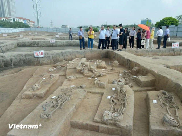 Researchers and media representatives explore the excavation pits at Vuon Chuoi, witnessing history being unearthed.