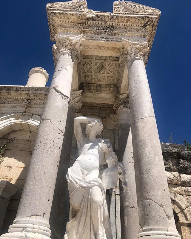 The Heroon of Sagalassos, featuring a statue and ornate carvings that exemplify Roman artistry.