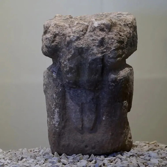 The backside of the anthropomorphic statue from Göbeklitepe, highlighting its detailed carving and weathered texture. 