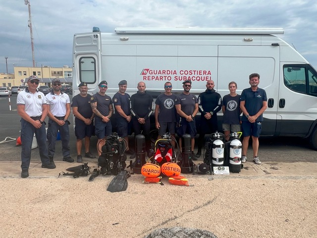 The dedicated team of archaeologists and diving experts from the Kaukana Project, standing next to their equipment after the successful excavation.