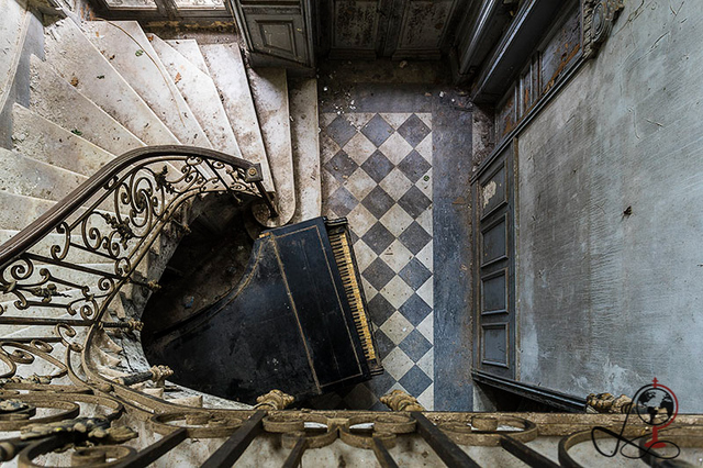 The dilapidated grand staircase and broken piano evoke the bittersweet beauty of decay inside Chateau Verdure.