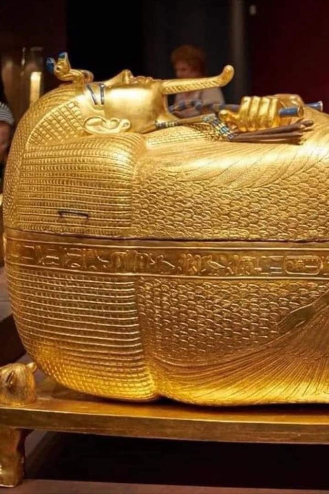 The gilded outer coffin of King Tutankhamun, adorned with intricate carvings and hieroglyphs symbolizing eternal life.