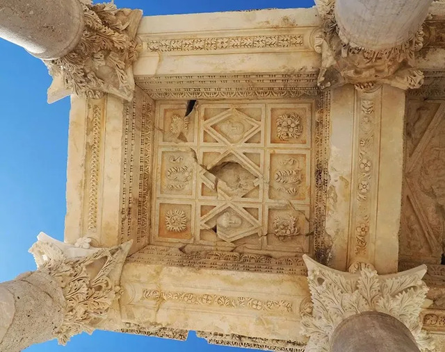 The intricately carved ceiling of the monumental entrance gate, a masterpiece of Roman architectural brilliance.