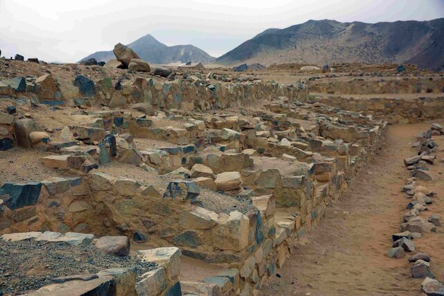 The layered stone terraces in Caral, highlighting its sophisticated urban planning techniques.