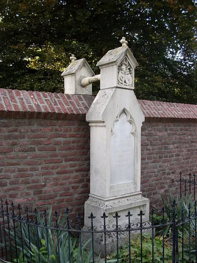 The monument features two sandstone columns with gable-shaped tops, rising higher than the dividing wall between them.