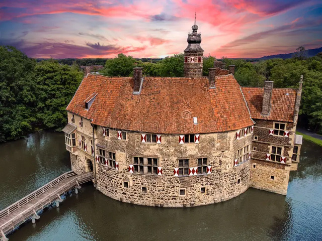 The picturesque silhouette of Vischering Castle during a vibrant sunset, highlighting its medieval architecture.