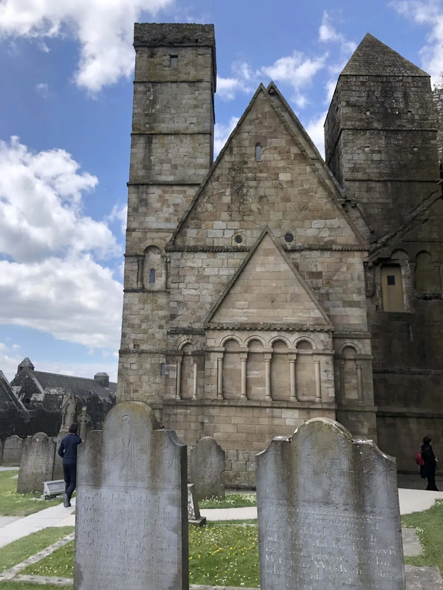 The rear view of the chapel surrounded by ancient gravestones, marking it as a site of reverence and historical significance.