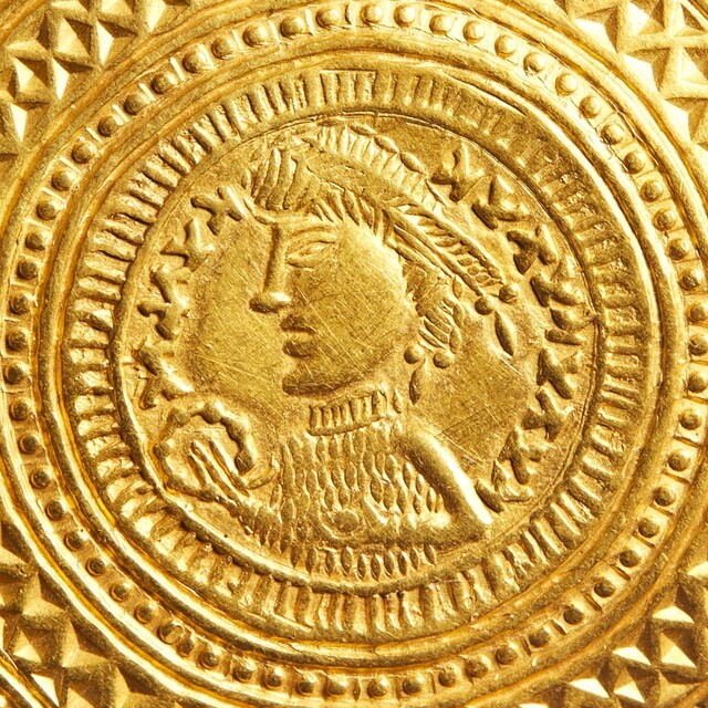 The ring-bearer depicted on the Vindelev Hoard bracteates is adorned in a high-necked, textured, scale-like garment that may symbolize a chainmail tunic similar to the one unearthed at the Løsning Søndermark excavation.