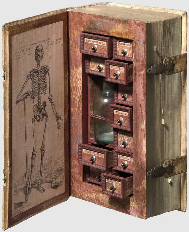 A detailed view of the "Assassin Cabinet," a 17th-century hollowed-out book with 11 meticulously labeled drawers designed for storing toxic and medicinal substances.