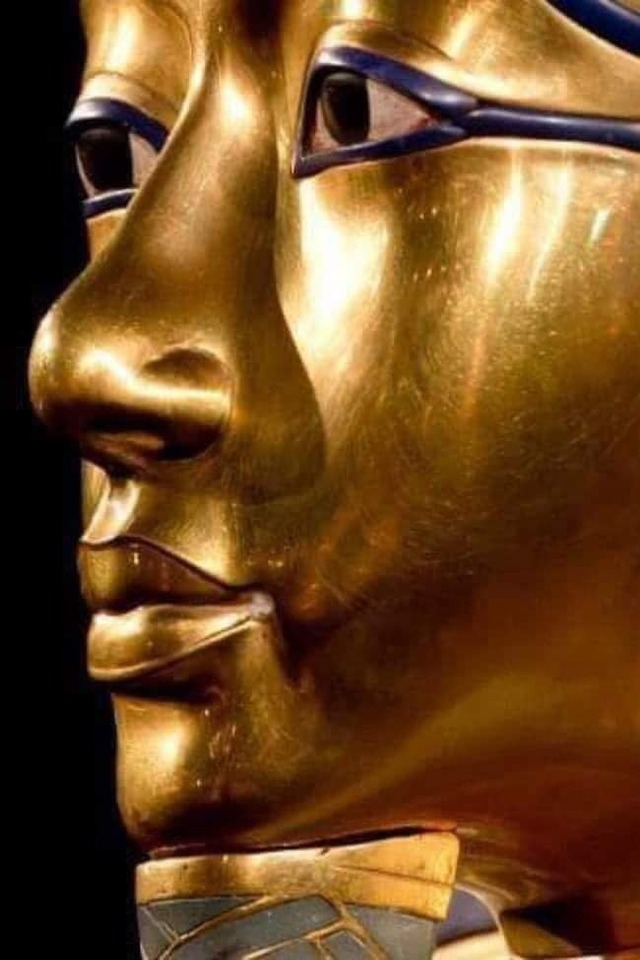 The side profile of King Tutankhamun's golden mask, emphasizing the flawless details of his features, enhanced with inlaid gemstones.