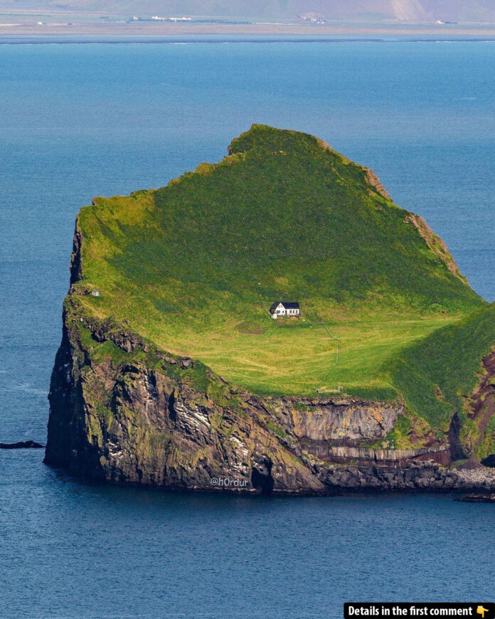 The world’s loneliest house stands proudly amidst the green slopes of Elliðaey Island.