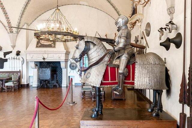 This grand hall is a treasure trove of medieval artifacts, showcasing a collection of armor, swords, and other weaponry