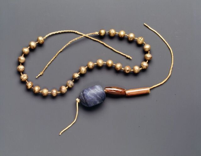 This necklace of gold ball beads highlights the sophistication and elegance of ancient Egyptian jewelry design.