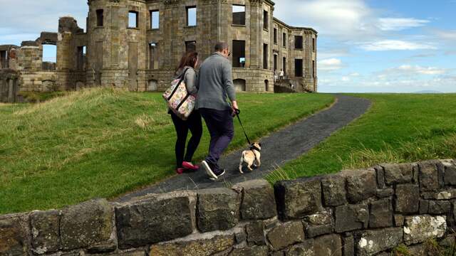 Visitors stroll along the path towards the remains of Downhill House, a perfect spot for exploring history with a scenic backdrop.