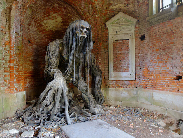 This chilling statue of a demon dominates the interior of the mausoleum, blending seamlessly with the eerie brickwork and decay.