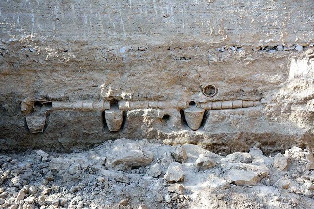 A closer shot of the ancient clay pipes and vessels embedded in the wall, highlighting the intricate design and advanced engineering of the water distribution system. (Credit: Mehr News Agency)