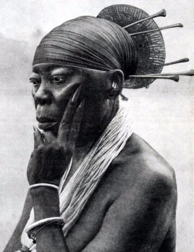 A Mangbetu elder with an elaborately styled coiffure, emphasizing the elongated head as a mark of dignity, wisdom, and status within the community.