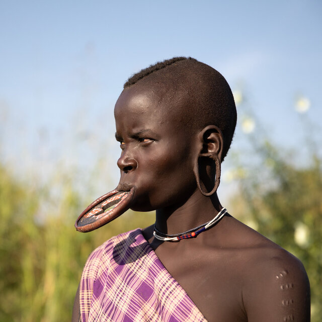 A Mursi woman from Ethiopia’s Omo Valley proudly wears a tribal lip plate, celebrating a time-honored cultural practice. (Credit: Jayne Mclean) 