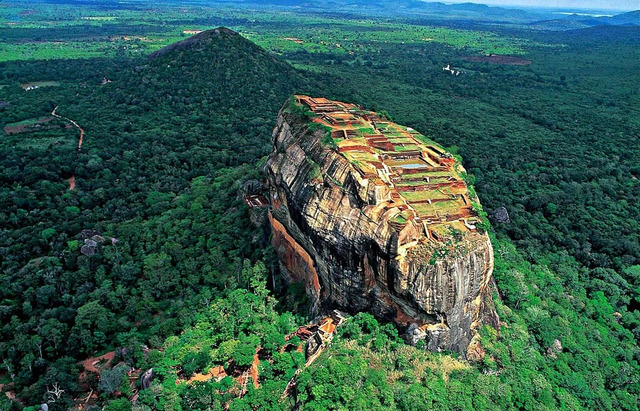 A breathtaking aerial view of Sigiriya, "The Lion Rock," showcasing its towering height and the remnants of the ancient citadel built by King Kashyapa I in Sri Lanka's central plains.