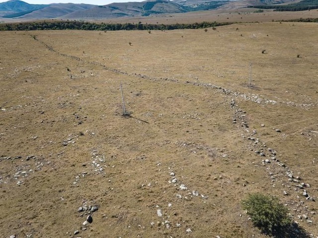 A captivating image of the 1-kilometer-long outer fortification wall, with power line poles nearby providing a sense of scale. (Credit: Nathaniel Erb-Satullo)