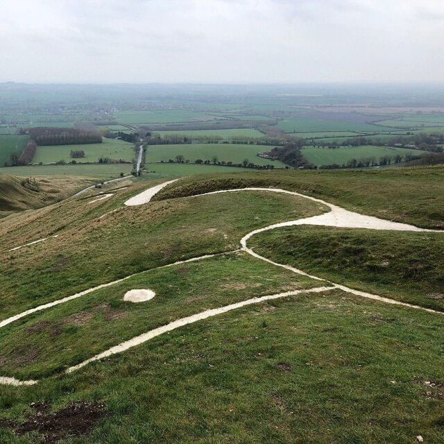 A close-up perspective of the chalk outline of the Uffington White Horse, showcasing the detailed craftsmanship that has endured for over 3,000 years.