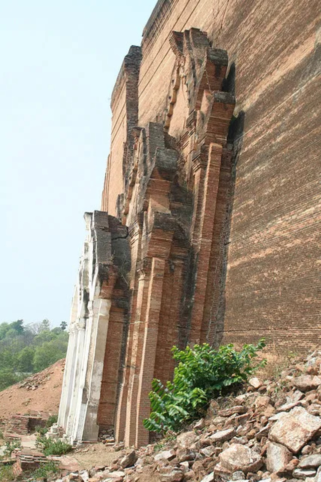 A detailed look at the intricate brickwork and eroded facade of the unfinished stupa, showcasing its architectural scale. 