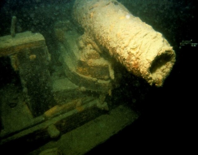 A detailed view of a cannon aboard one of the wrecks, illustrating the ships' heavy armaments and their instability as war vessels.