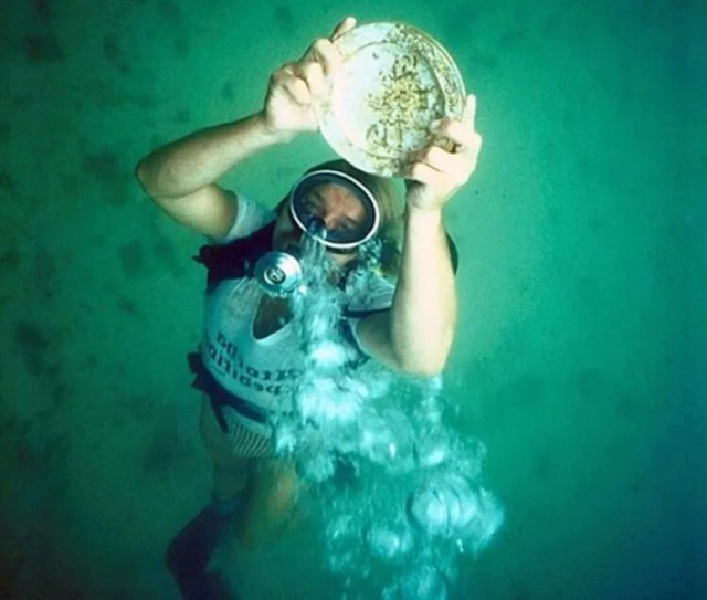 A diver showcasing an engraved gold plate discovered during the exploration of the Santa Margarita wreck. Credit: Don Kincade.