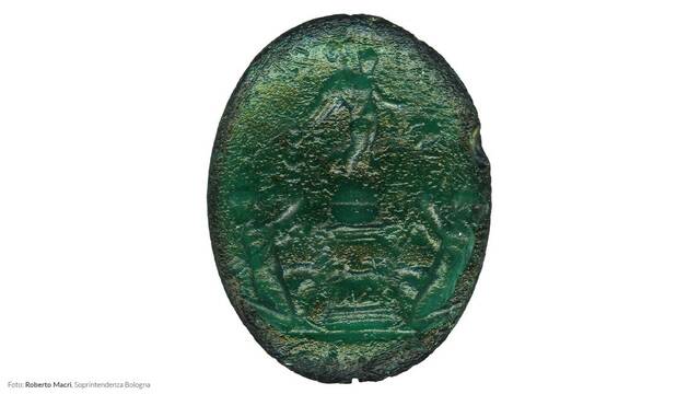 A green Roman gemstone engraved with symbolic imagery, adding to the cultural narrative of Claterna's Roman past.