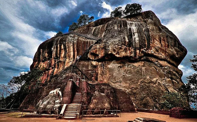 A ground-level perspective of the Sigiriya rock, portraying the dramatic ascent to the fortress atop its summit.