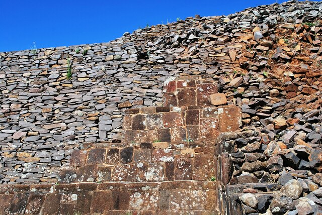 A partially reconstructed yácata reveals the intricate stone facing that once adorned its exterior, offering a glimpse into its former splendor.