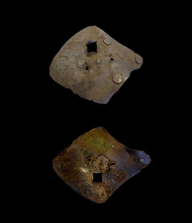 A square cross-sectioned piece of armor pierced by a weapon or projectile—a stark reminder of battlefield realities.