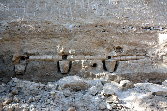 A straight-on view of the exposed aqueduct components, giving a clear perspective of the alignment and placement of the clay pipes and vessels in the wall. (Credit: Mehr News Agency)