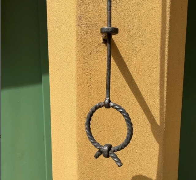 A unique wrought iron doorbell pull adds character to the entrance of an apartment in Fuggerei.