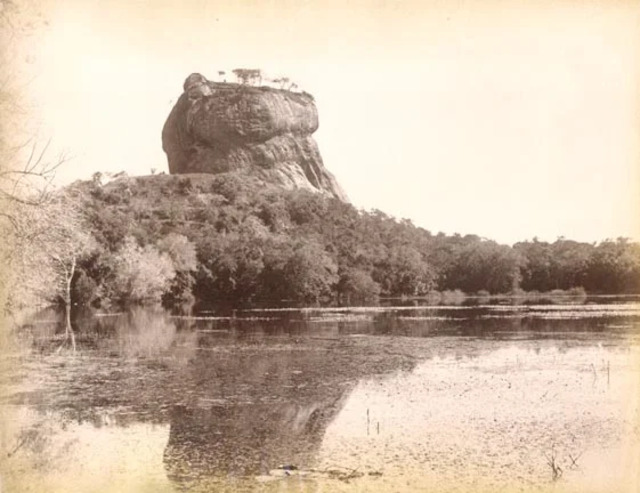 An antique photograph of Sigiriya Rock taken in the 19th century, reflecting its imposing presence amid the surrounding wilderness.