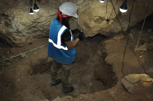 An archaeologist carefully excavates a section of İnkaya Cave, unveiling traces of human life dating back 86,000 years. Credit: Ankara University.