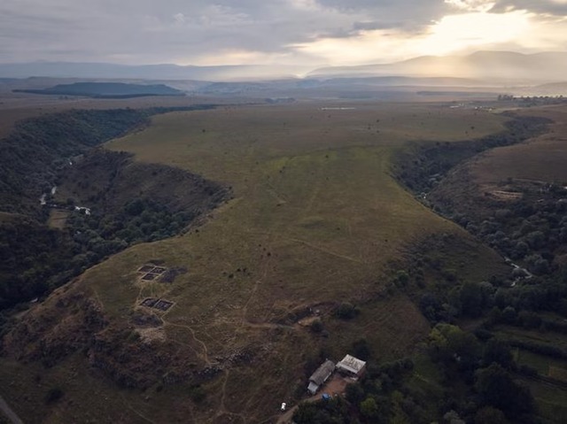 An atmospheric photograph of the site at dusk highlights its striking location at the confluence of two dramatic gorges. (Credit: Nathaniel Erb-Satullo)