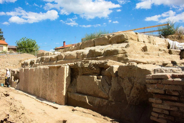 Archaeologists meticulously examining and documenting the sandstone steps that served as the entrance to the capitolium temple.