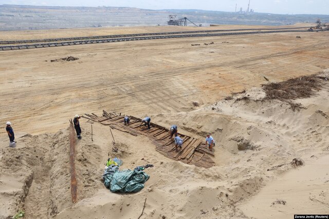 Archaeologists near Kostolac, Serbia, carefully uncover the woodwork of an ancient Roman ship on August 2, following its discovery by an excavation crew at the Drmno mine.