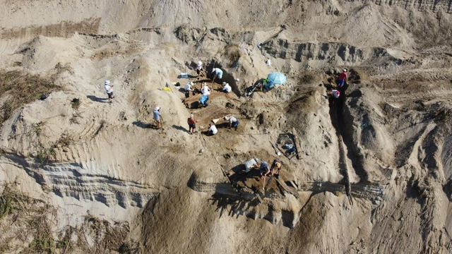 Archaeologists working diligently in the excavation pit to uncover the Roman-era ship buried 25 feet beneath layers of silt and soil. (Credit: Institute of Archaeology, Belgrade)