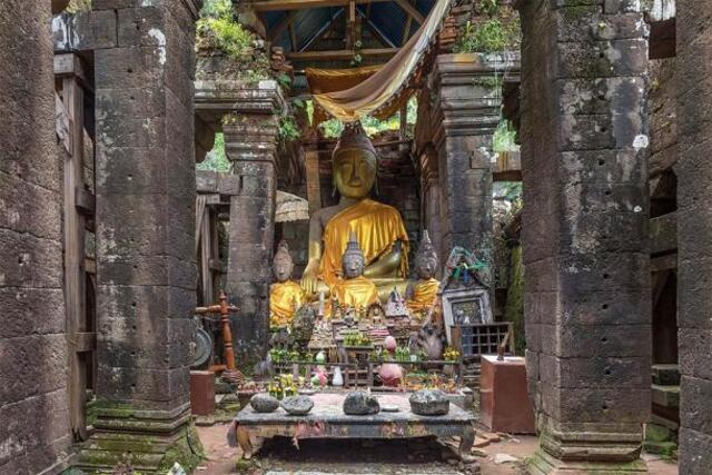 At the heart of Vat Phou Temple lies a serene scene of seated Buddha statues, a table of sacred stones, and Buddhist relics. (Credit: Basile Morin / CC BY-SA 4.0)